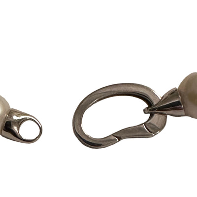 Close-up of a pearl necklace with a clasp on a light gray background